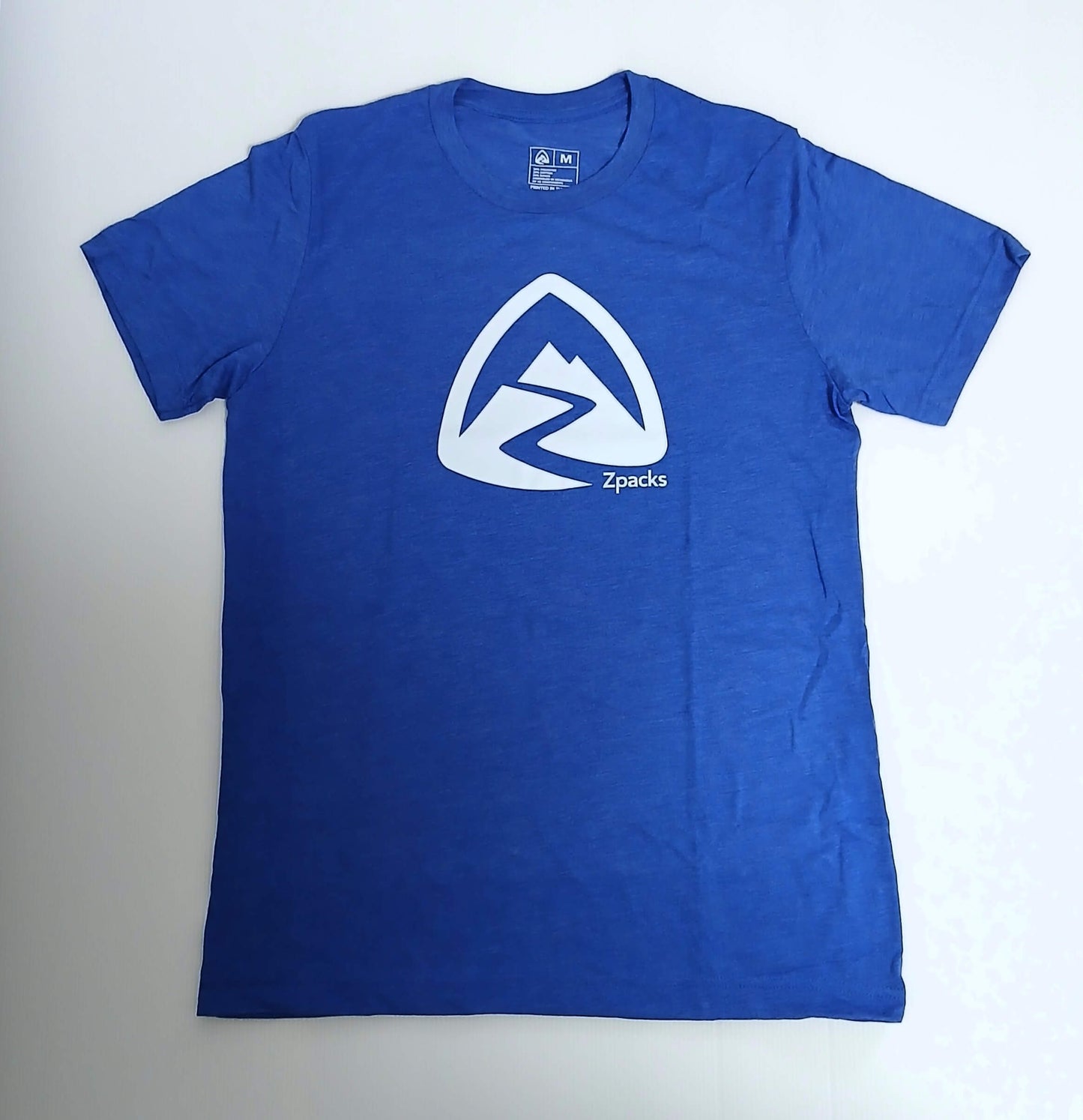 Zpacks Crest T-Shirt クレストTシャツ ブルーのMサイズを平置きした前身頃の全体。霜降り調のトライブレンド生地と白いクレストロゴがわかる実物写真 - 山道具とULギアのお店 Ascend Lite