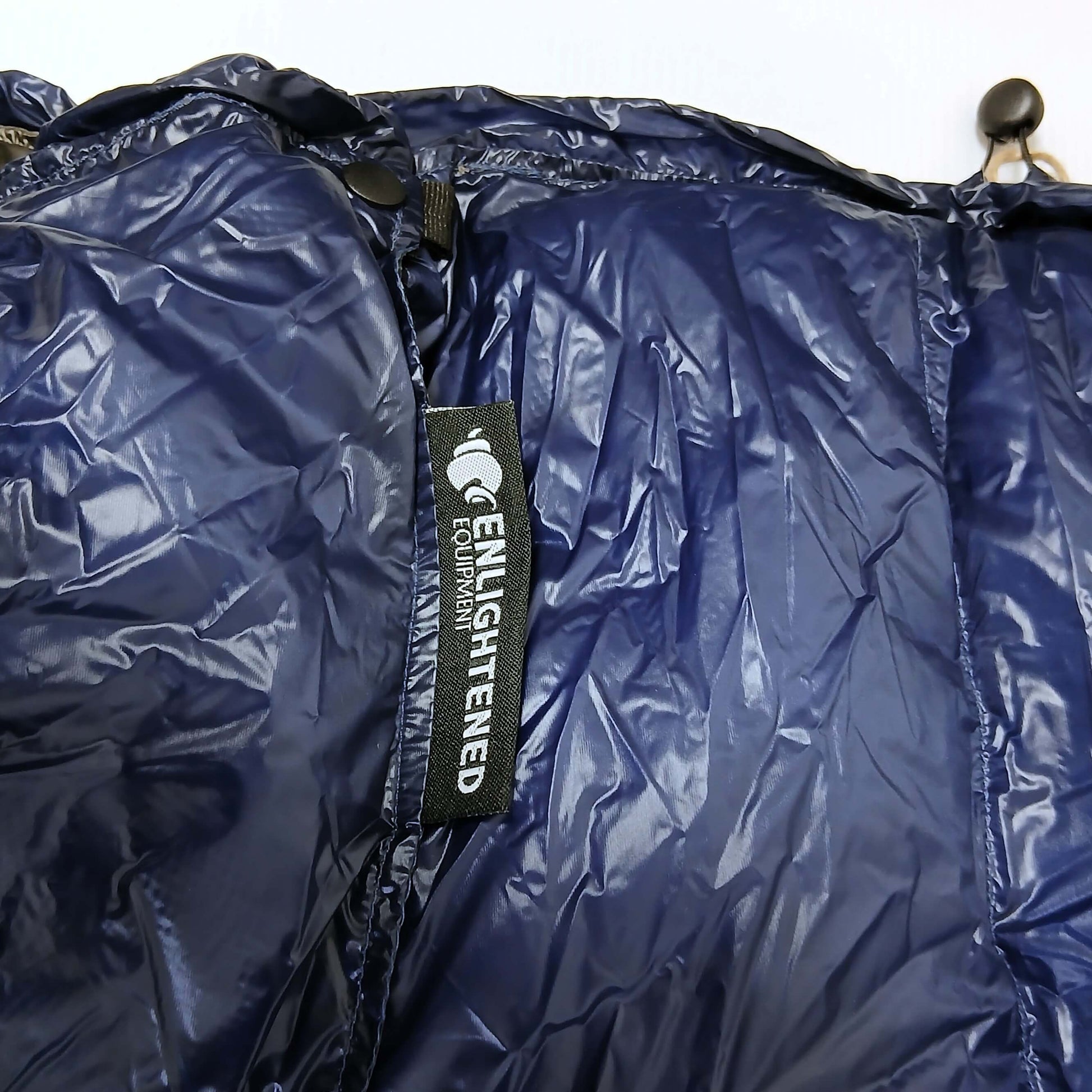 Enlightened Equipment Revelation Sleeping Quilt 50°F Navy 10D 首元の拡大・スナップとドローコード・コードロック、縫い付けられたブランドラベルの実物写真 - 山道具とULギアのお店 Ascend Lite