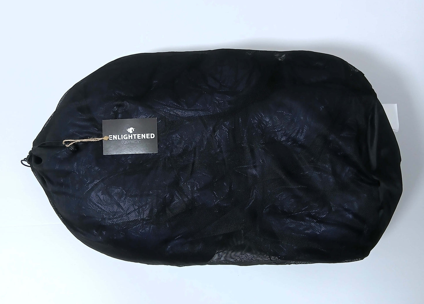 Enlightened Equipment Revelation Sleeping Quilt 50°F 付属のポリエステル製ストレージサック（黒のメッシュ素材）に収めて平置きした実物写真 - 山道具とULギアのお店 Ascend Lite