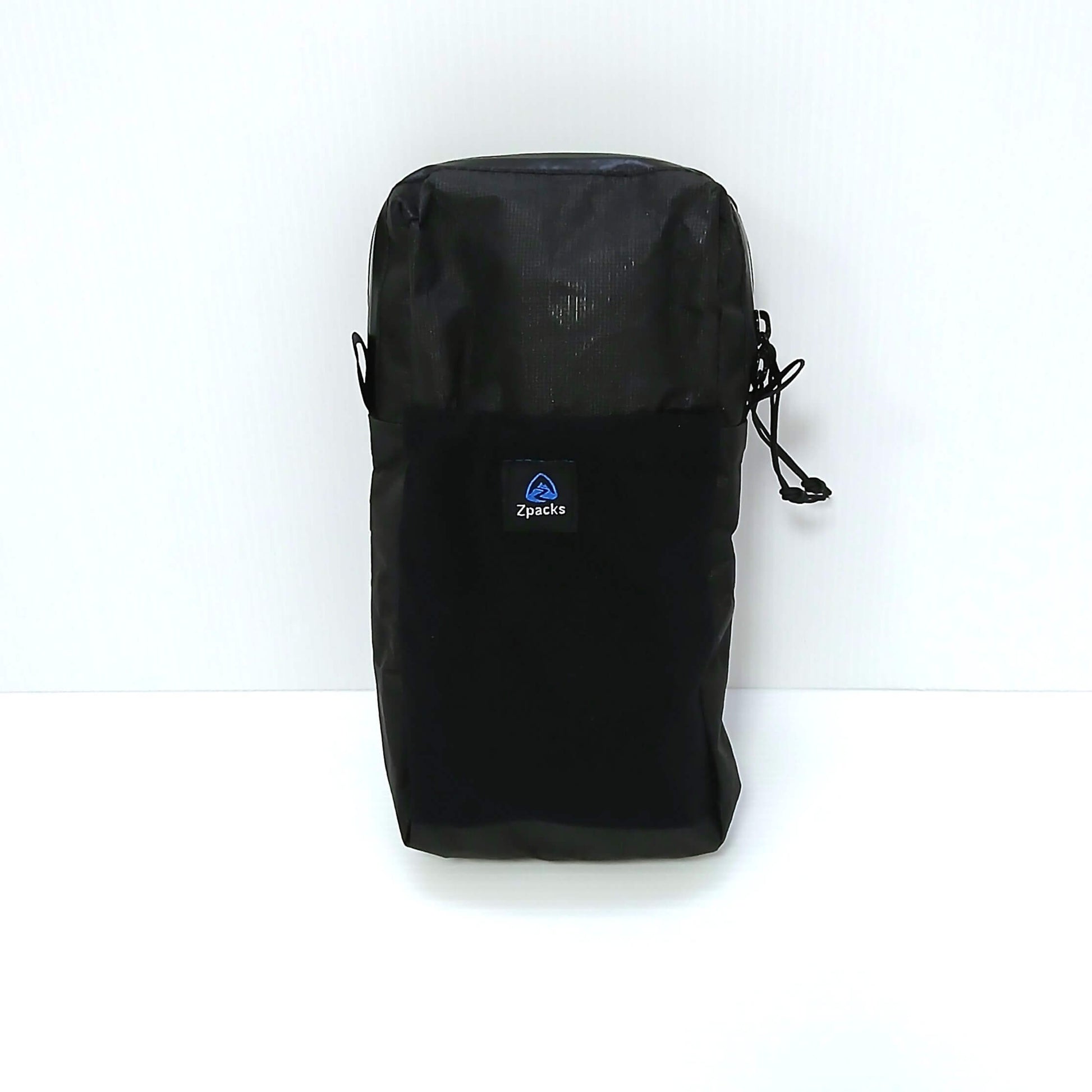 Zpacks Shoulder Pouch w/ Zipper ショルダーポーチ ジッパー付き Jet Black Ultra 立てた状態の正面、閉じたラップアラウンド止水ジッパーと右サイドに垂れるループ状プルコード、Zpacksロゴタグ付き伸縮メッシュポケットの実物写真 - 山道具とULギアのお店 Ascend Lite