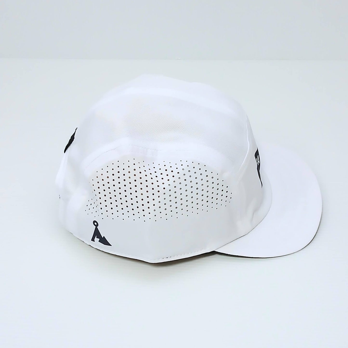 VAGA Feather Racing Cap フェザーレーシングキャップ ホワイト 実物写真 斜め後ろ - サイドパネル一面に広がるレーザーカットの通気ホールと後ろ寄りのネイビーの山型ロゴ - 山道具とULギアのお店 Ascend Lite