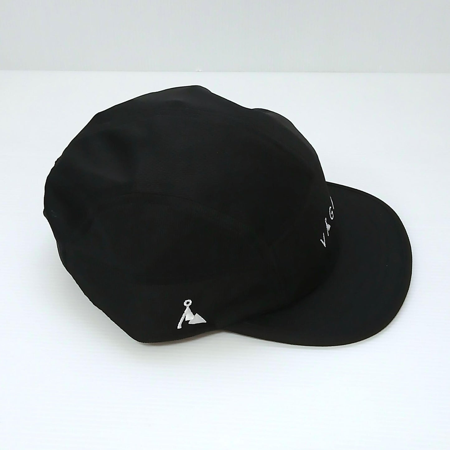 VAGA Club Cap クラブキャップ ストームブラック 実物写真 真横やや後ろ - サイドパネルの白い山型ロゴと前寄りのVAGAロゴ、ゆるく反った5cmショートピーク - 山道具とULギアのお店 Ascend Lite