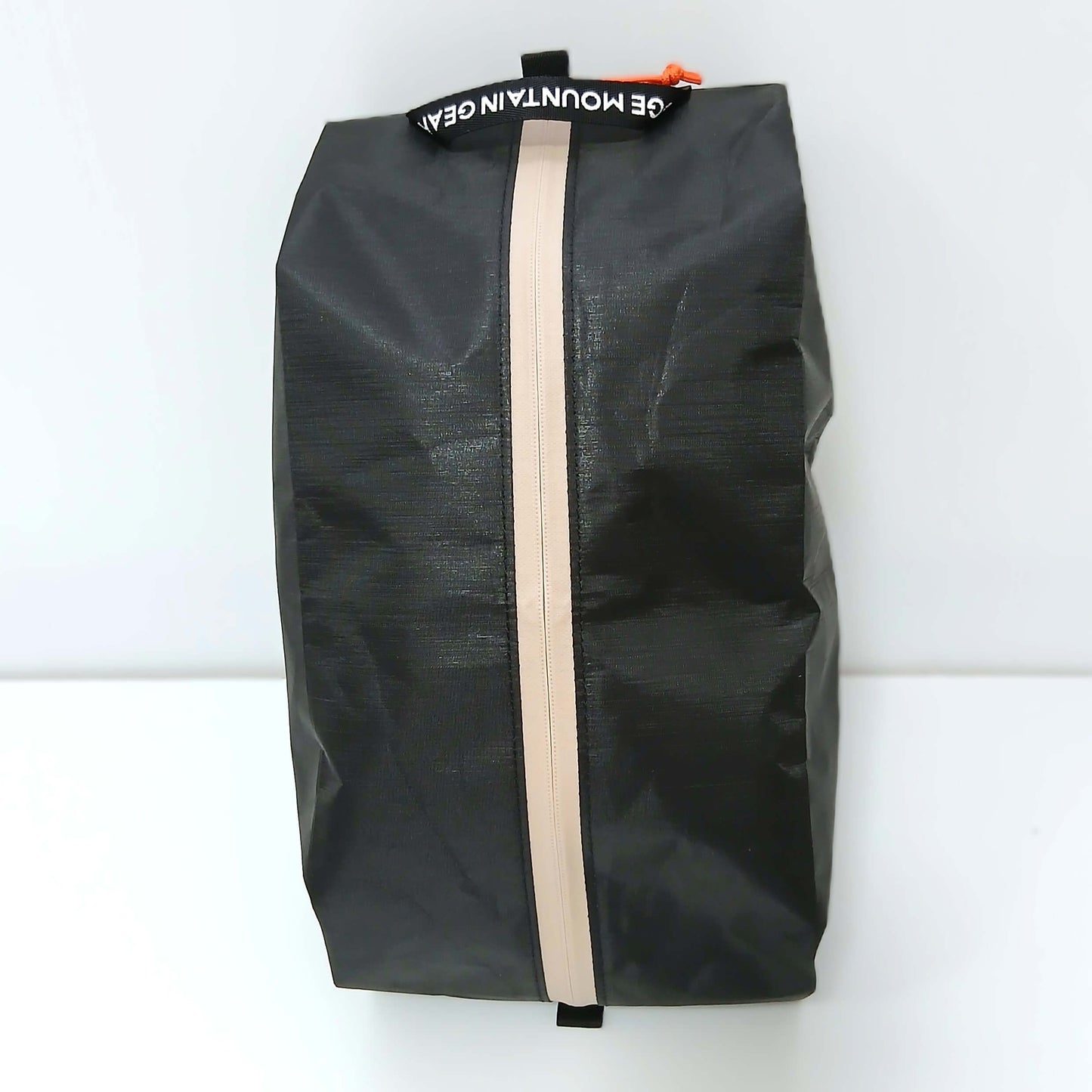 RIDGE MOUNTAIN GEAR Case L ケースL Solid Black を立てて正面から見たファスナー面 縦に走る止水ファスナーとオレンジのジッパープルの実物写真 - 山道具とULギアのお店 Ascend Lite