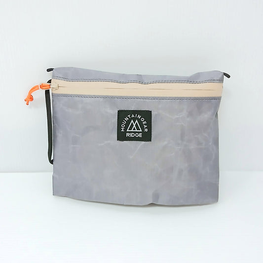 RIDGE MOUNTAIN GEAR Travel Pouch Plus トラベルポーチプラス 中身を入れて膨らませた正面（ロゴタグとオレンジのジッパープル） - 山道具とULギアのお店 Ascend Lite