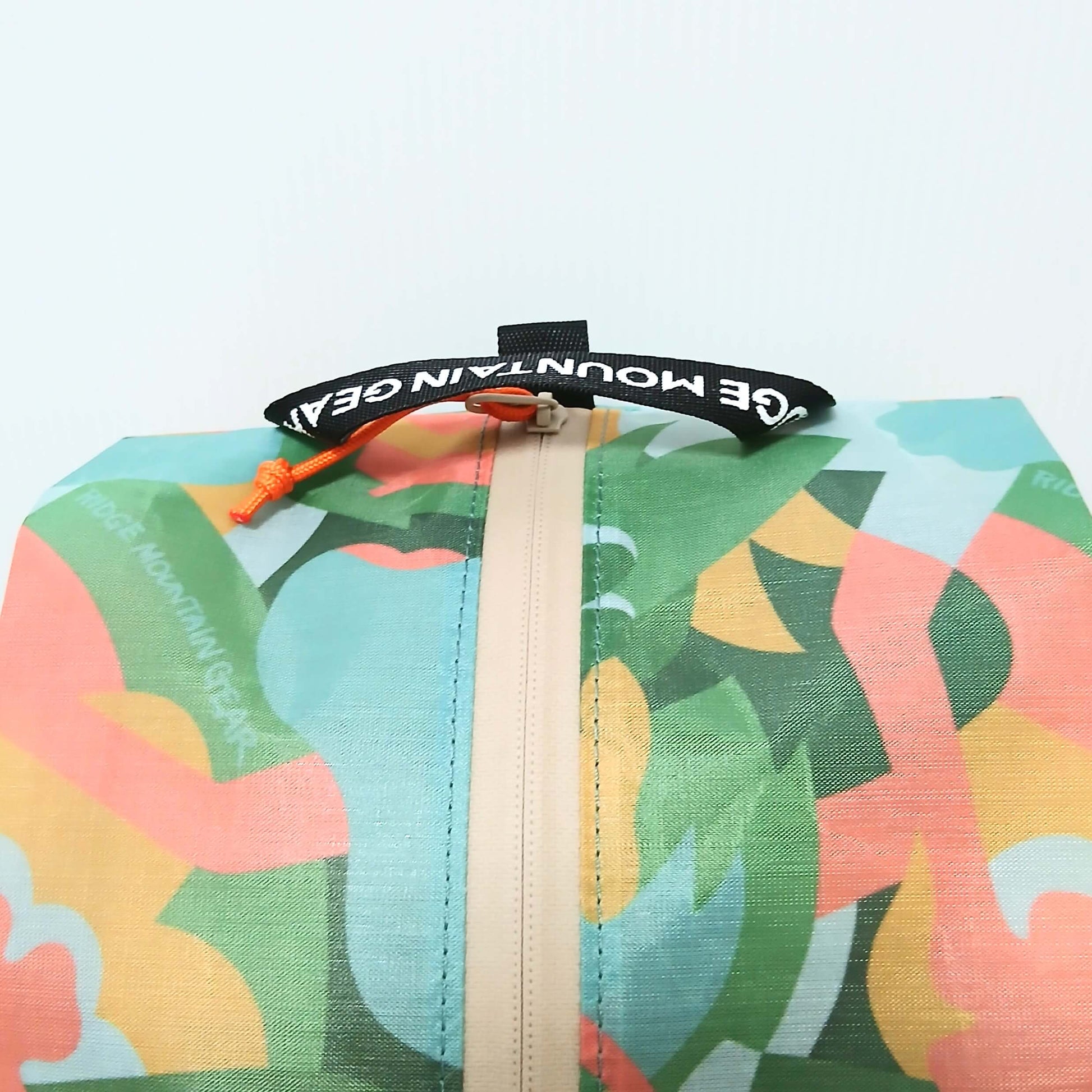 RIDGE MOUNTAIN GEAR JUN OSON×RIDGE Case M ケースM 上部のブランドロゴ入りウェビングループとオレンジのジッパープル周辺のクローズアップの実物写真 - 山道具とULギアのお店 Ascend Lite