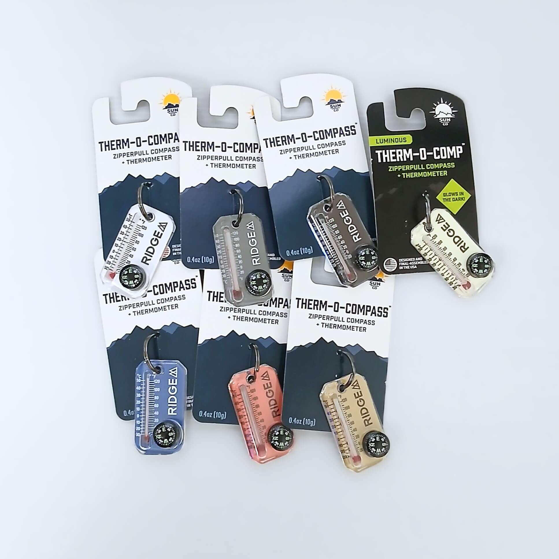 RIDGE MOUNTAIN GEAR Therm-o-compass サーモコンパス 全7色（White・Grey・Black・LumaGage・Palace Blue・Bubblegum・Soft Sand）をパッケージ台紙付きで並べた実物写真 - 山道具とULギアのお店 Ascend Lite