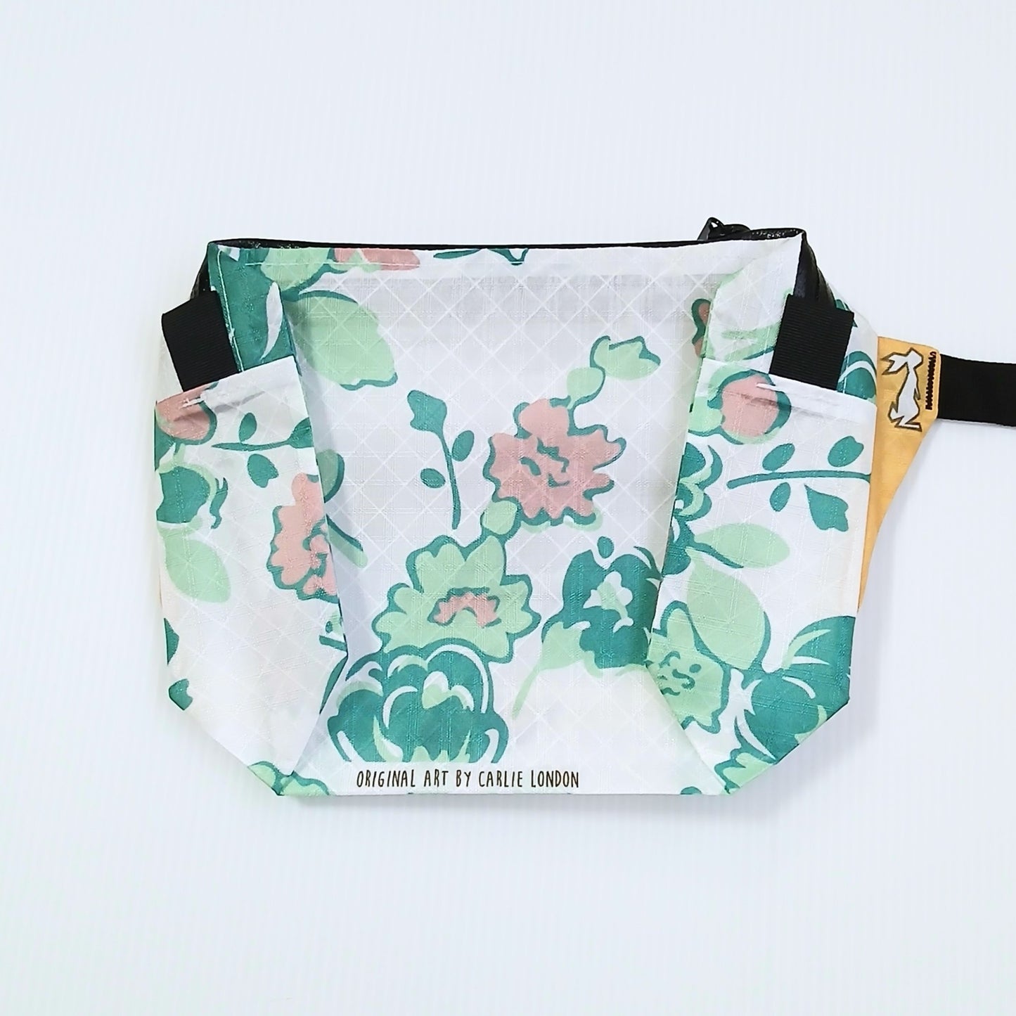 High Tail Designs The Ultralight Fanny Pack ファニーパック Floral 白地にグリーンとサーモンピンクの花を水彩調で描いた柄の正面全体と、下端のアーティストクレジット印字の実物写真 - 山道具とULギアのお店 Ascend Lite