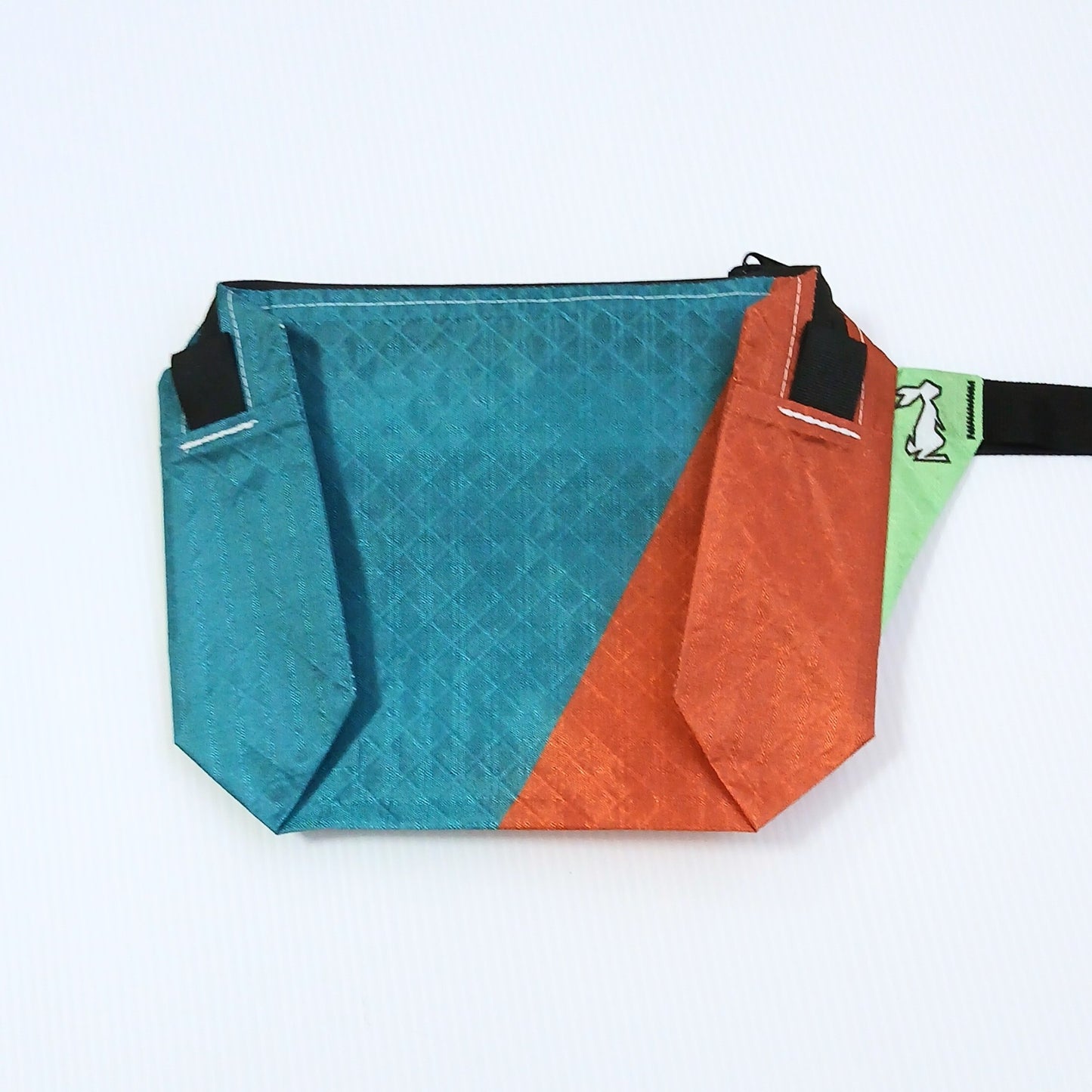 High Tail Designs The Ultralight Fanny Pack ファニーパック Rusty Mint ティールとオレンジを斜めに切り替えた配色の正面全体と、ライトグリーンのストラップ基部の実物写真 - 山道具とULギアのお店 Ascend Lite