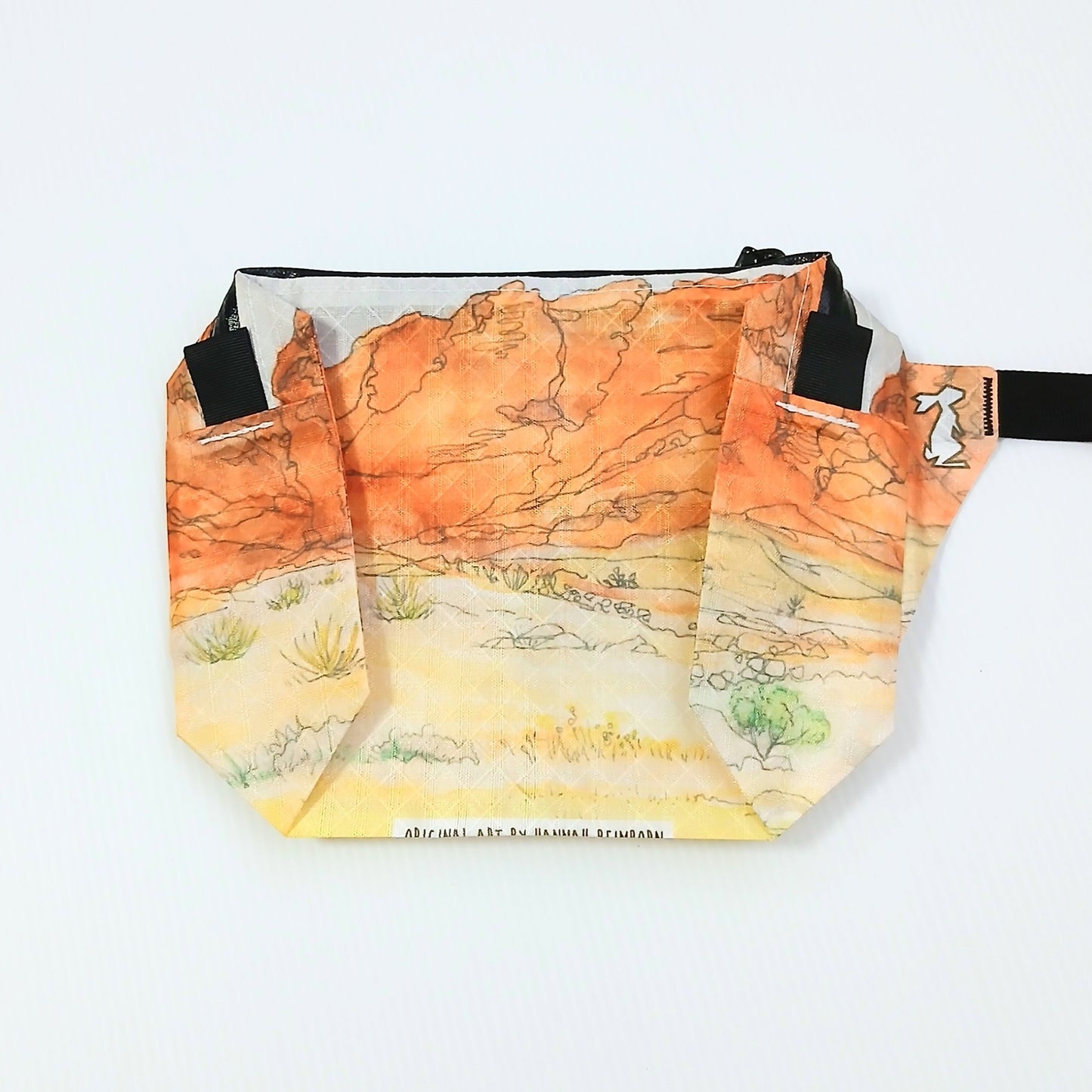High Tail Designs The Ultralight Fanny Pack ファニーパック Red Rock Canyon（Hannah Beimborn） 朱色の岩壁と黄土色の砂地・低木を水彩線画で描いた柄の正面全体と、右サイドポケットに描かれた緑の樹の実物写真 - 山道具とULギアのお店 Ascend Lite