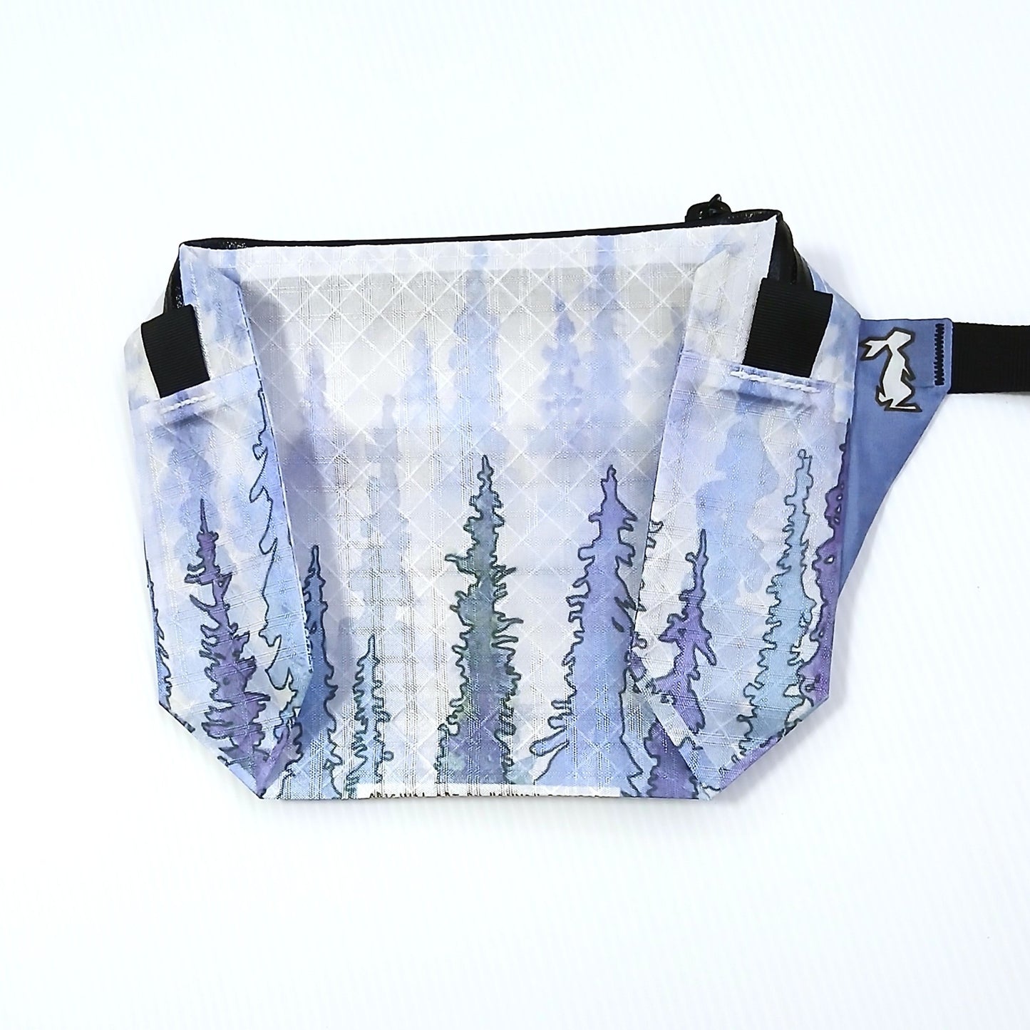 High Tail Designs The Ultralight Fanny Pack ファニーパック Snowy Trees（Hannah Beimborn） 淡い青紫のにじみの中に細い針葉樹が縦に並ぶ柄の正面全体と、同色ブルーのストラップ基部の実物写真 - 山道具とULギアのお店 Ascend Lite