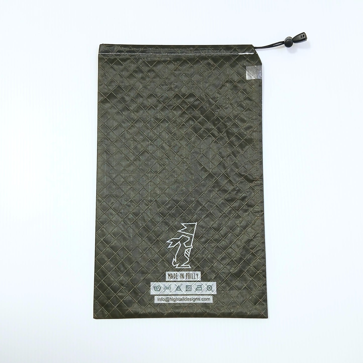 High Tail Designs Ultralight Drawstring Stuff Sack ドローストリングスタッフサック Ink 深いオリーブグレーの無地、生地の45度クロス格子が浮かぶ表面に白いウサギロゴと洗濯表示の印字の実物写真 - 山道具とULギアのお店 Ascend Lite