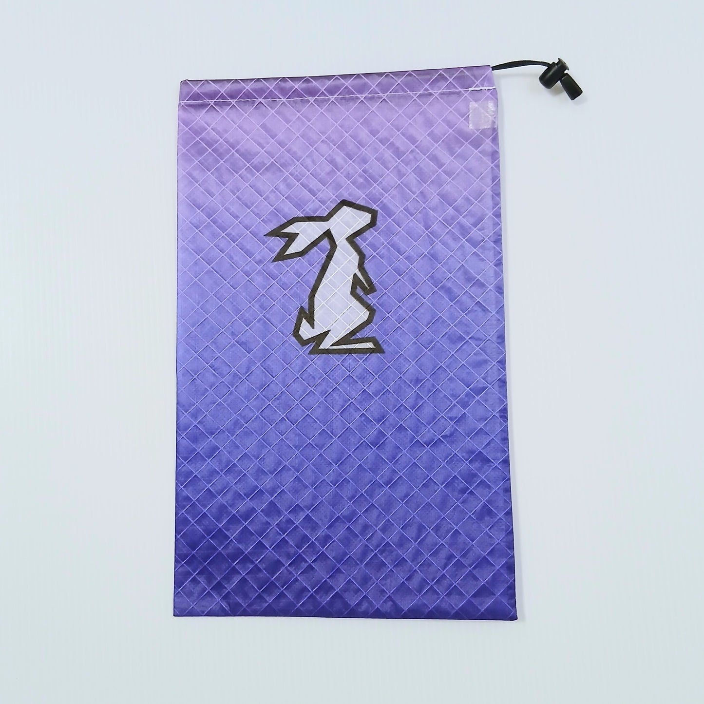 High Tail Designs Ultralight Drawstring Stuff Sack ドローストリングスタッフサック Glacial 淡いラベンダーから青紫へ沈むグラデーション柄、中央に白抜きのウサギ輪郭ロゴ、右上に黒いコードロックの実物写真 - 山道具とULギアのお店 Ascend Lite