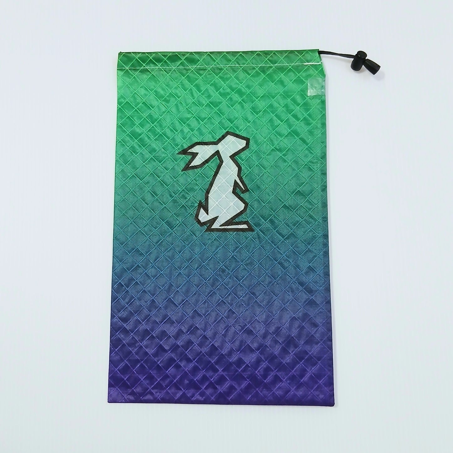 High Tail Designs Ultralight Drawstring Stuff Sack ドローストリングスタッフサック Interstellar 緑からティール・青紫へ移るグラデーション柄、中央に白いウサギのシルエットの実物写真 - 山道具とULギアのお店 Ascend Lite