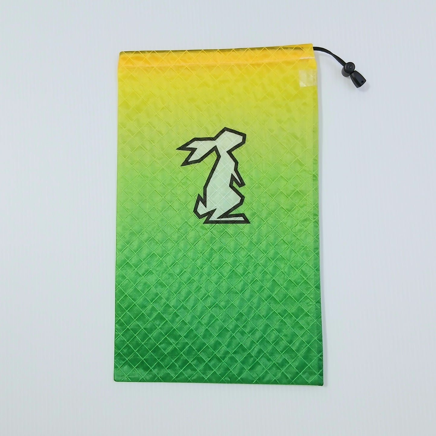 High Tail Designs Ultralight Drawstring Stuff Sack ドローストリングスタッフサック Limeade レモンイエローから鮮やかなグリーンへ下るグラデーション柄、中央に淡い黄緑のウサギ輪郭ロゴの実物写真 - 山道具とULギアのお店 Ascend Lite