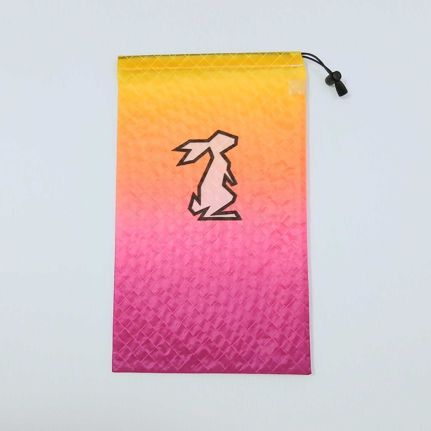 High Tail Designs Ultralight Drawstring Stuff Sack ドローストリングスタッフサック Pink Lemonade レモンイエローからオレンジ・マゼンタピンクへ移るグラデーション柄、中央に淡ピンクのウサギ輪郭ロゴの実物写真 - 山道具とULギアのお店 Ascend Lite