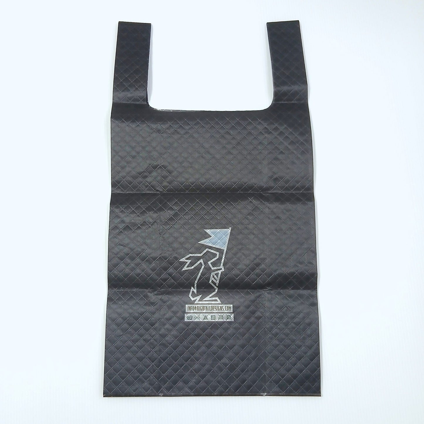 High Tail Designs TX Small Shopping Bag ショッピングバッグ S Ink 光沢のある黒無地に斜め45°のクロスプライ格子が浮かび、中央に白線のうさぎのブランドロゴと水色の旗をプリント。横一文字の折り目が残る幅広ハンドルの平置き正面全体とロゴ下のケアタグの実物写真 - 山道具とULギアのお店 Ascend Lite