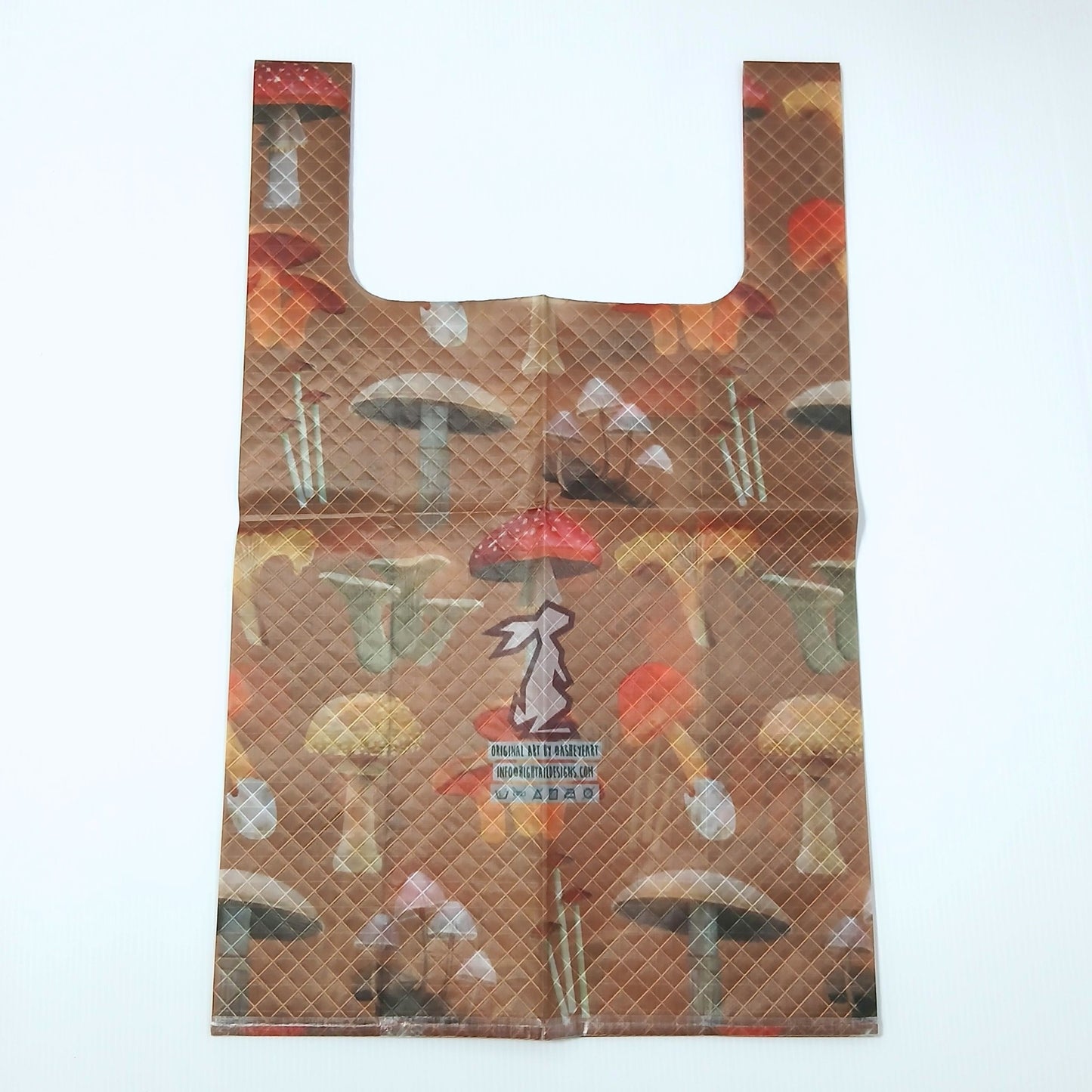 High Tail Designs TX Medium Shopping Bag ショッピングバッグ M Botany Poster（Ash Ryan） 茶色地に赤い傘の毒キノコや白・黄のキノコを並べた植物図鑑調の柄、中央に紫のうさぎのブランドロゴとアーティストクレジット印字のケアタグ。平置き正面全体の実物写真 - 山道具とULギアのお店 Ascend Lite