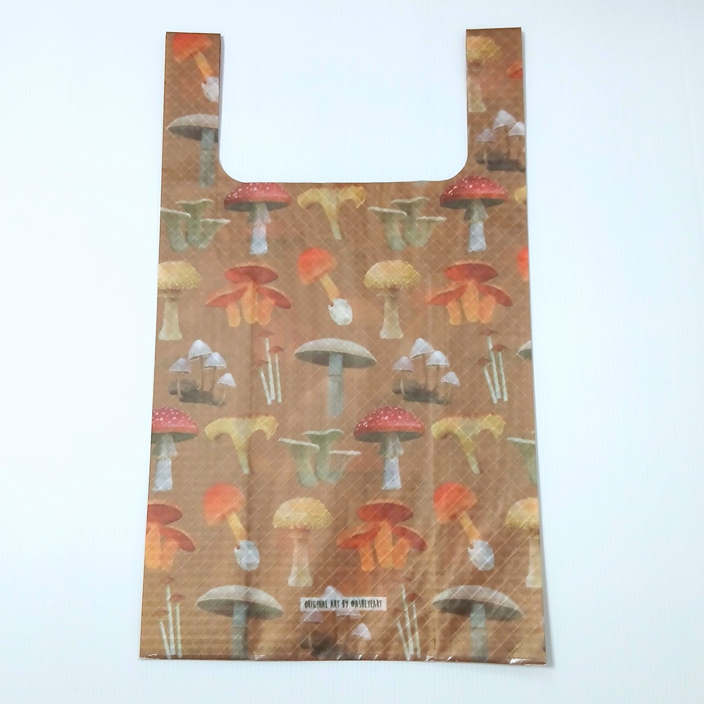 High Tail Designs TX Medium Shopping Bag ショッピングバッグ M Botany Poster（Ash Ryan）TX50 茶色地に赤い傘の毒キノコや白・黄・橙のキノコを図鑑のように整列させた柄。細身ハンドルで深さのあるシルエットの平置き正面全体と、下部中央のアーティストクレジット印字ケアタグの実物写真 - 山道具とULギアのお店 Ascend Lite
