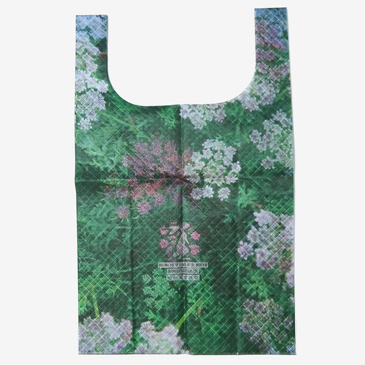 High Tail Designs TX Large Shopping Bag ショッピングバッグ L Alpine Flora（Flower of the Mountain） 深緑の草むらに白い散形花とピンクの小花が咲く風景写真をプリントした柄。折りジワの残る平置き全体と中央下のアーティストクレジット印字ケアタグの実物写真 - 山道具とULギアのお店 Ascend Lite