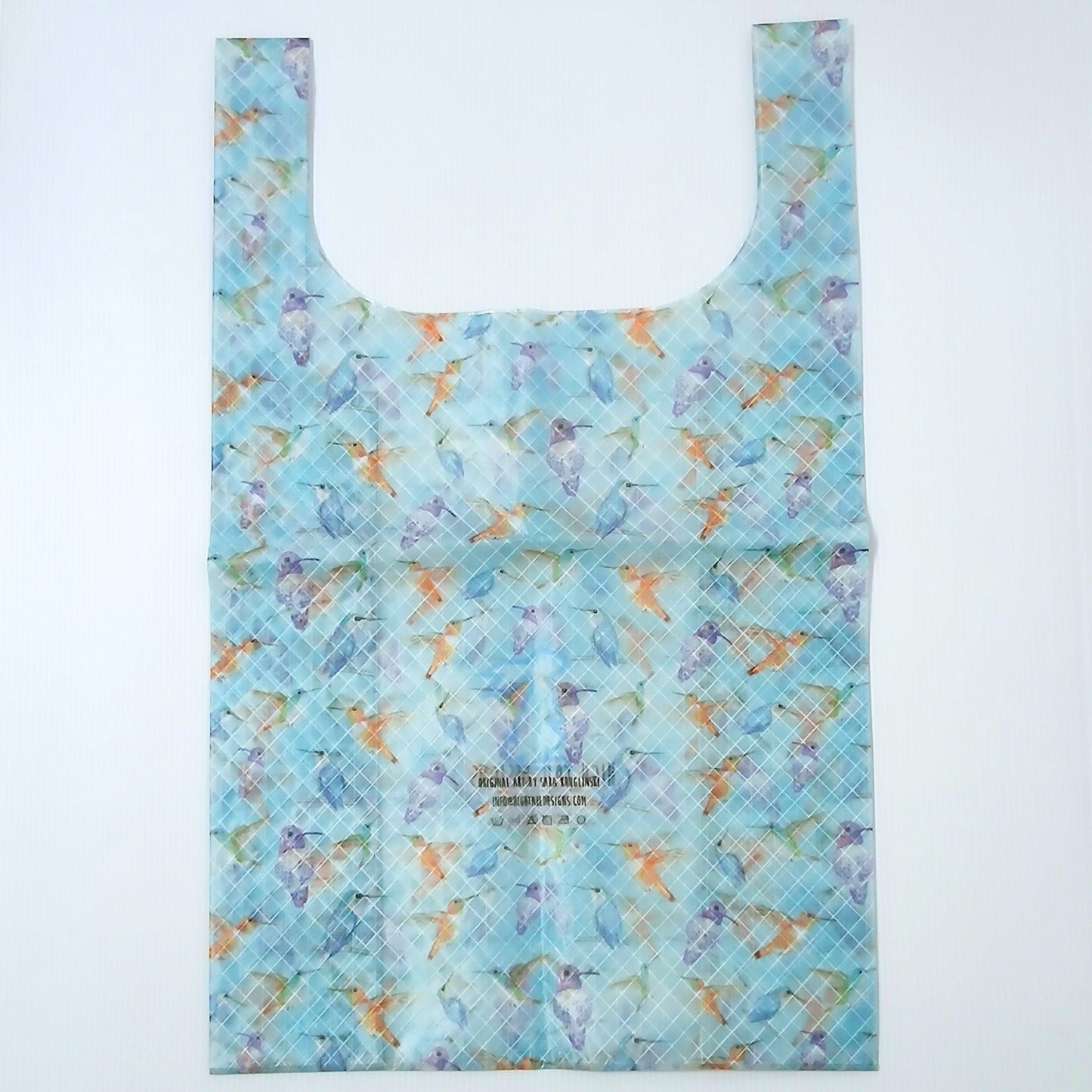 High Tail Designs TX Large Shopping Bag ショッピングバッグ L Hummingbirds（Sara Kruglinski） 水色の地に青・紫・オレンジのハチドリが水彩調で舞う柄。中央下のアーティストクレジット印字とケアタグ、横一文字の折り目が残る幅広ハンドルの平置き正面全体の実物写真 - 山道具とULギアのお店 Ascend Lite