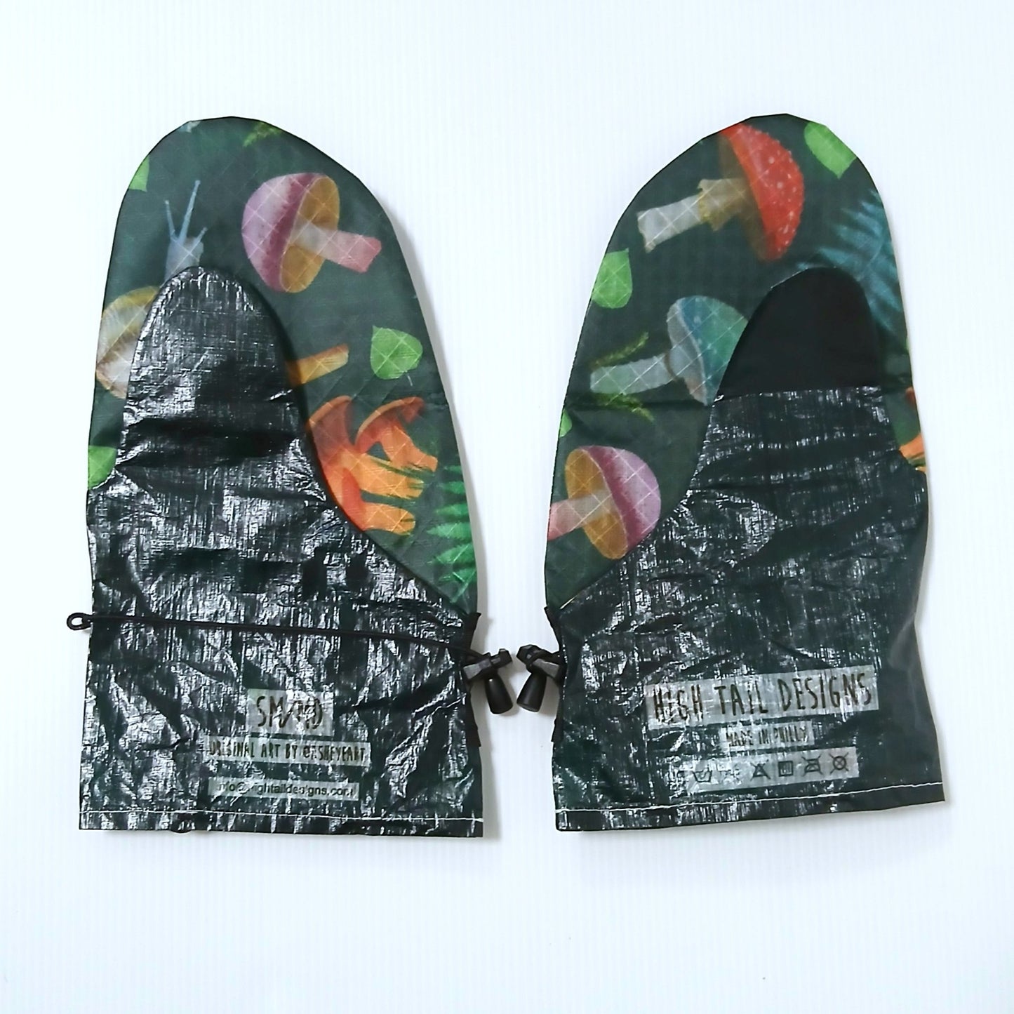 High Tail Designs Rain Mitt レインミット Forest Mushroom SM/MD（手のひらTX95） 深緑地に赤や桃色のキノコとシダを描いた柄が全面に入り、カフにアーティストクレジット印字とブランドロゴ、左右一対を甲側から並べた実物写真 - 山道具とULギアのお店 Ascend Lite