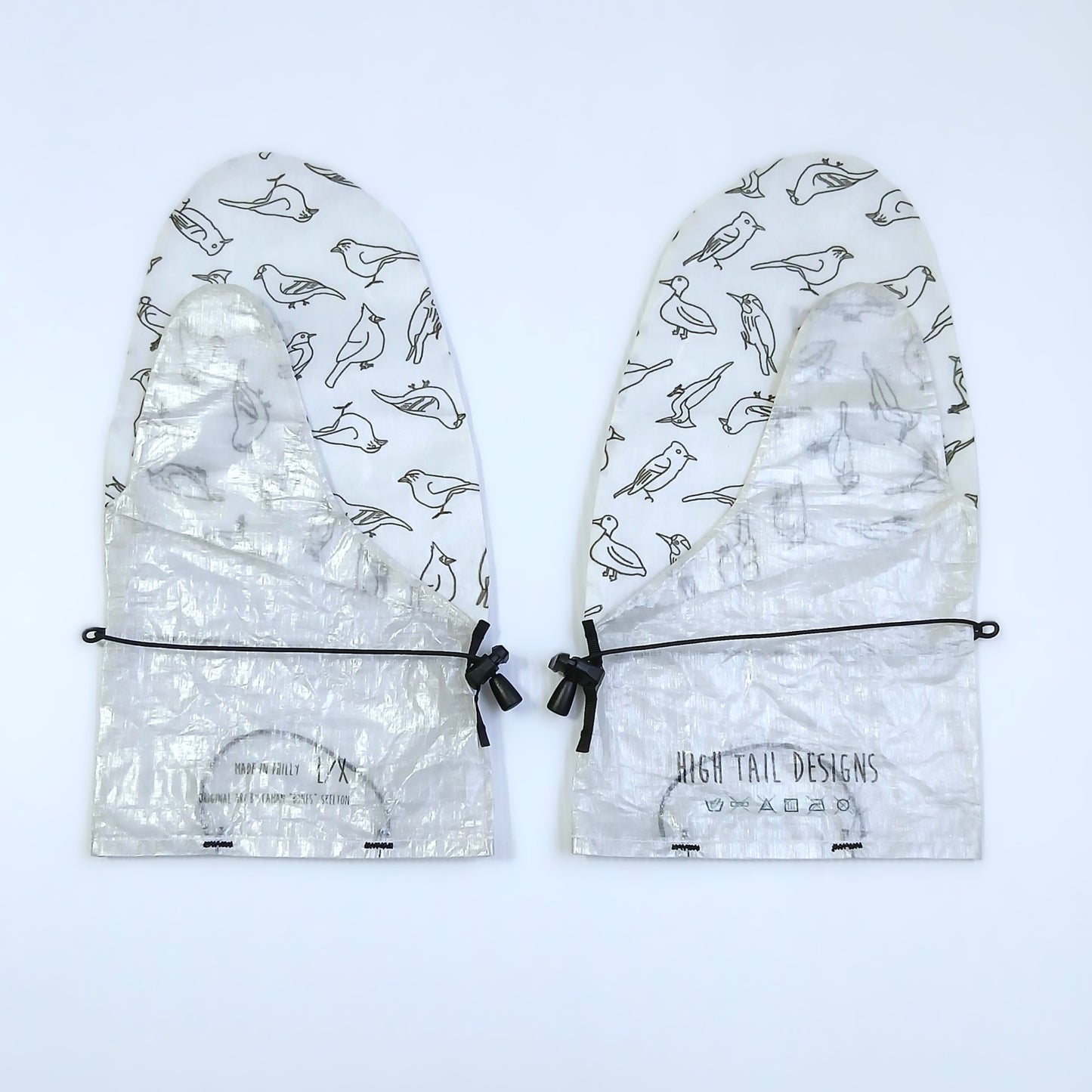 High Tail Designs Rain Mitt レインミット For The Birds LG/XL（手のひらDHF） 白地に黒線画の小鳥を甲一面に散らした柄、手のひらから下は箔のような皺の銀白無地、カフにブランドロゴと洗濯表示の印字、左右一対を甲側から並べた実物写真 - 山道具とULギアのお店 Ascend Lite