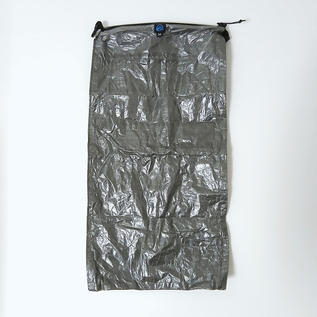 Zpacks Medium Pillow Dry Bag ミディアムピロードライバッグ - DCF面を上にして平置きした全体。上端のZpacksロゴタグとMサイズ表示、両端のロールトップ用フックの実物写真 - 山道具とULギアのお店 Ascend Lite