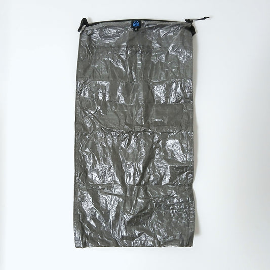 Zpacks Medium Pillow Dry Bag ミディアムピロードライバッグ - DCF面を上にして平置きした全体。上端のZpacksロゴタグとMサイズ表示、両端のロールトップ用フックの実物写真 - 山道具とULギアのお店 Ascend Lite