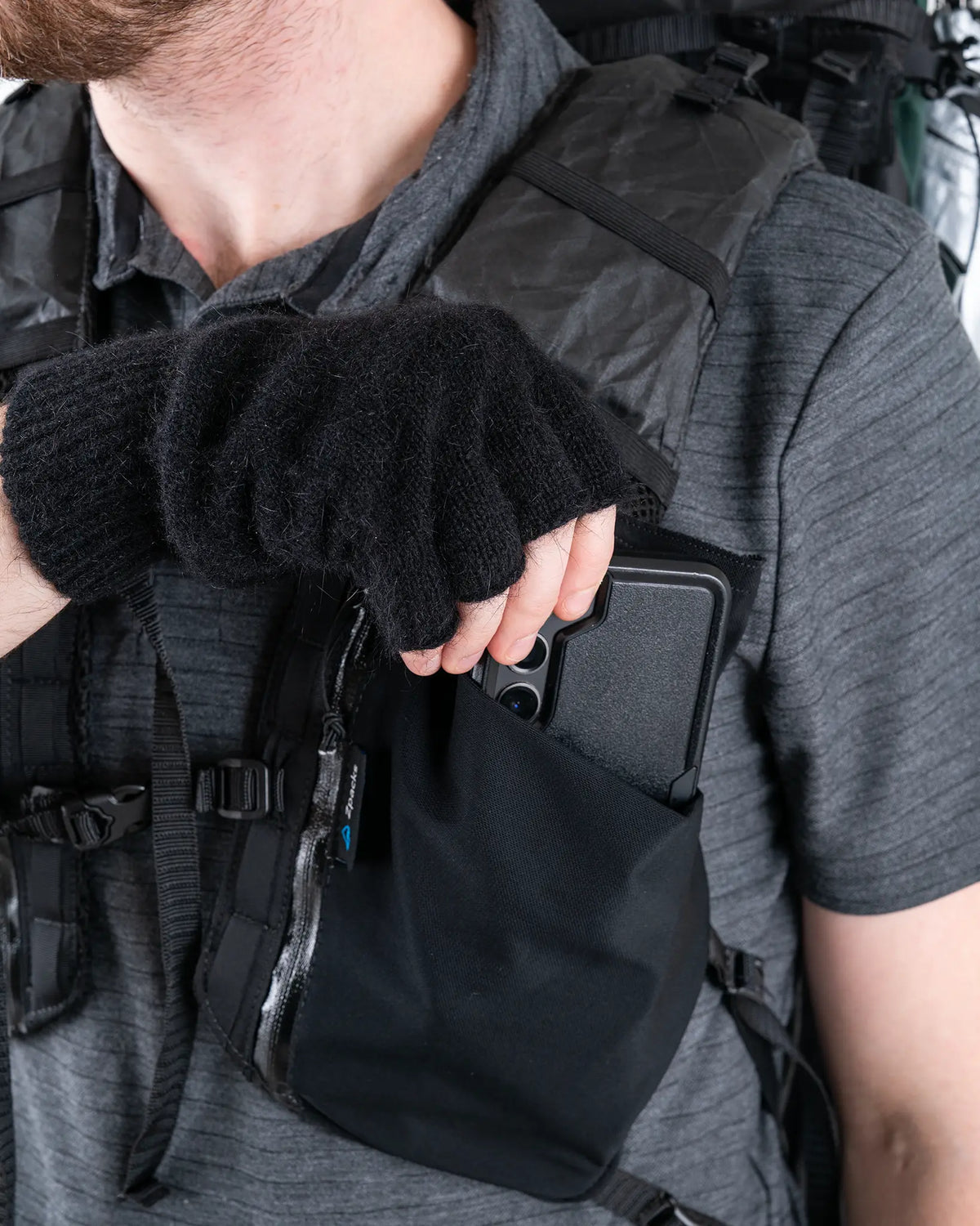 Zpacks Fingerless Brushtail Possum Gloves フィンガーレスブラシテールポッサムグローブ - 着用したままザックのショルダーストラップのポーチを開ける様子（公式画像） - 山道具とULギアのお店 Ascend Lite