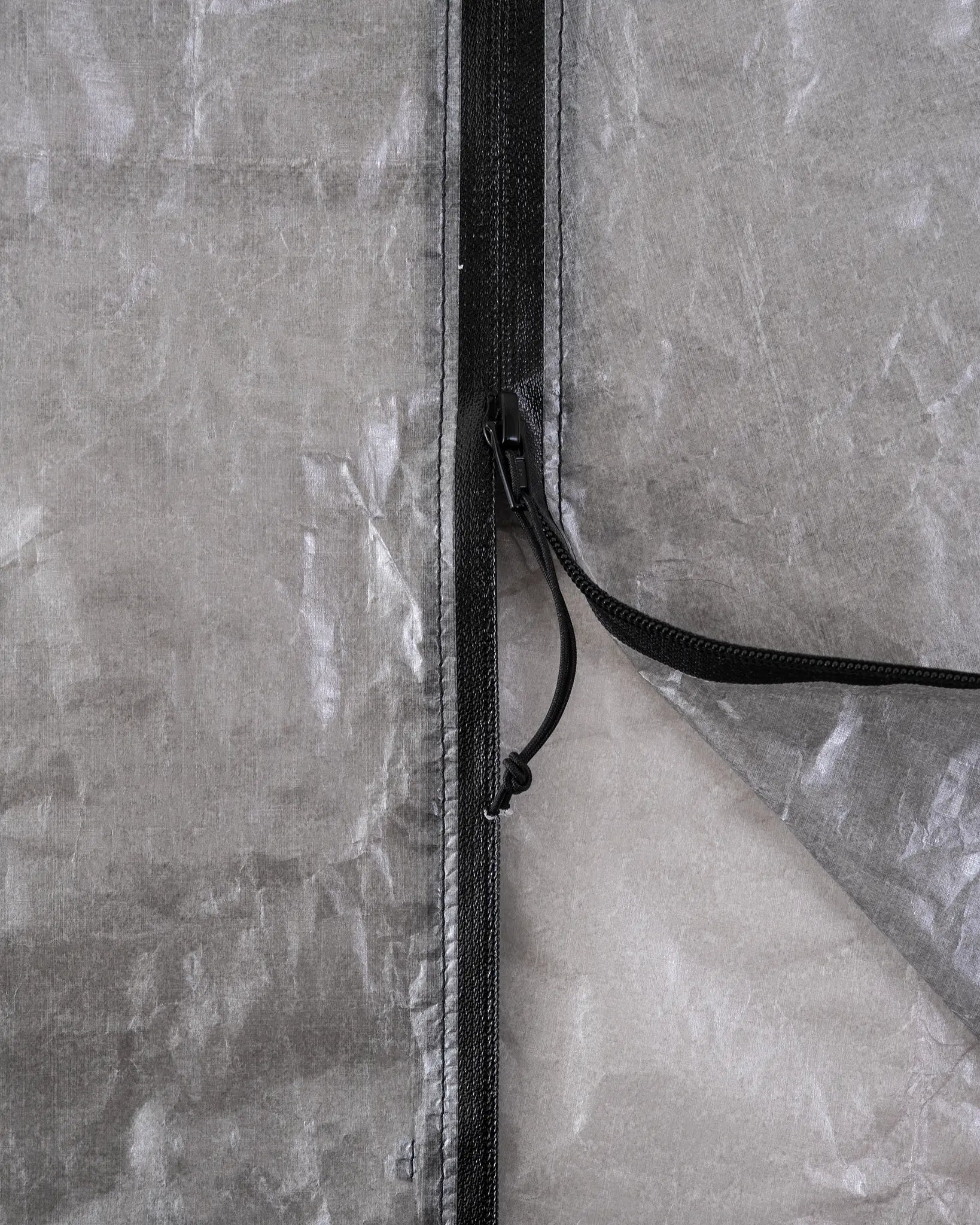 Zpacks DCF Rain Kilt DCFレインキルト ジッパー開閉部 - 途中まで開いた止水ジッパーの接写。黒いジッパーテープの縫い付けと、開口部から覗くDCFの裏面（公式画像） - 山道具とULギアのお店 Ascend Lite