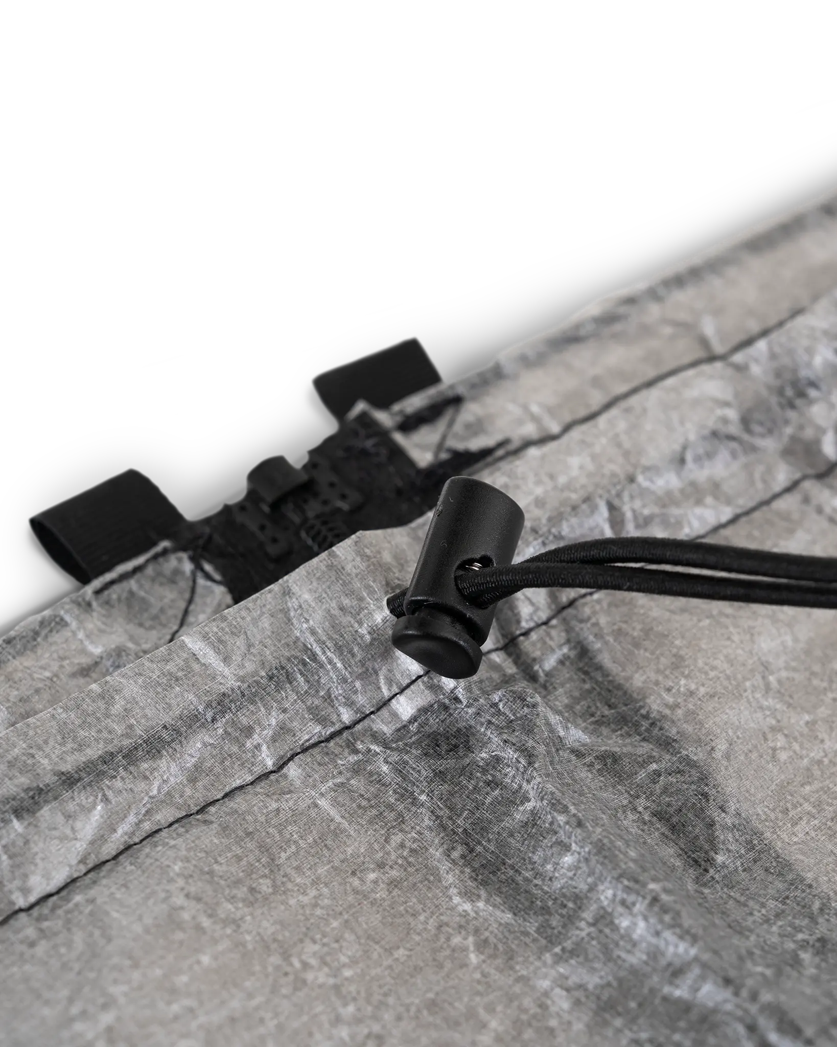 Zpacks DCF Rain Kilt DCFレインキルト ウエスト上端 - ドローコードを通した黒いコードロックの接写。隣にセパレーティングジッパーの上端が見える（公式画像） - 山道具とULギアのお店 Ascend Lite
