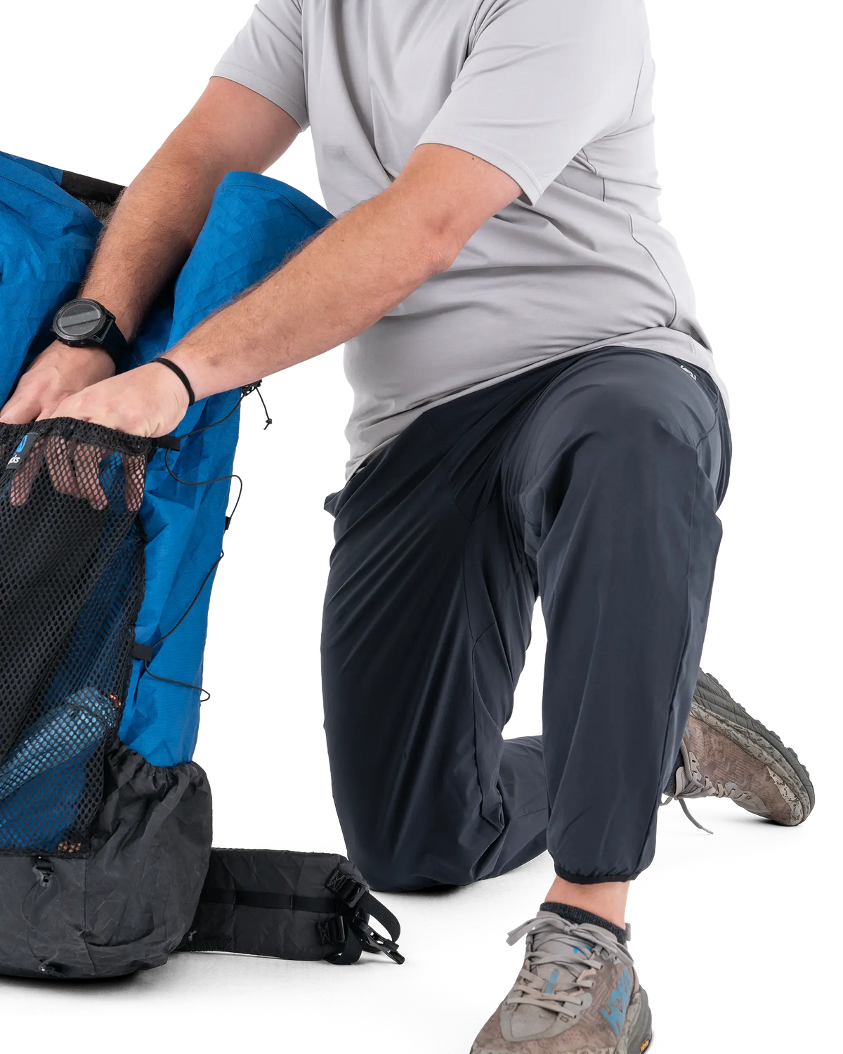 Zpacks Trail Cool Joggers トレイルクール ジョガーパンツ しゃがんでパックに荷物を詰める動作（公式画像） - 山道具とULギアのお店 Ascend Lite