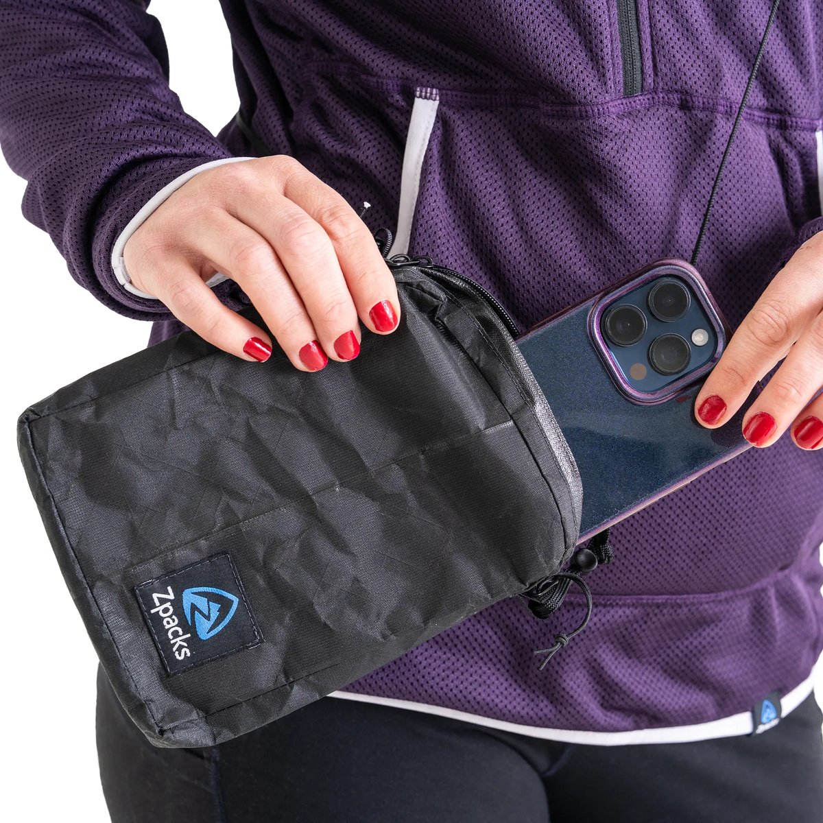 Zpacks Travel Utility Zip トラベルユーティリティジップ ブラック - 首から提げたまま収納部からスマートフォンを取り出すところ（公式画像） - 山道具とULギアのお店 Ascend Lite