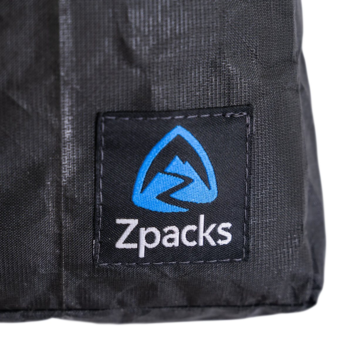 Zpacks Travel Utility Zip トラベルユーティリティジップ ブラック - Ultra 100X生地とZpacksロゴパッチのクローズアップ（公式画像） - 山道具とULギアのお店 Ascend Lite