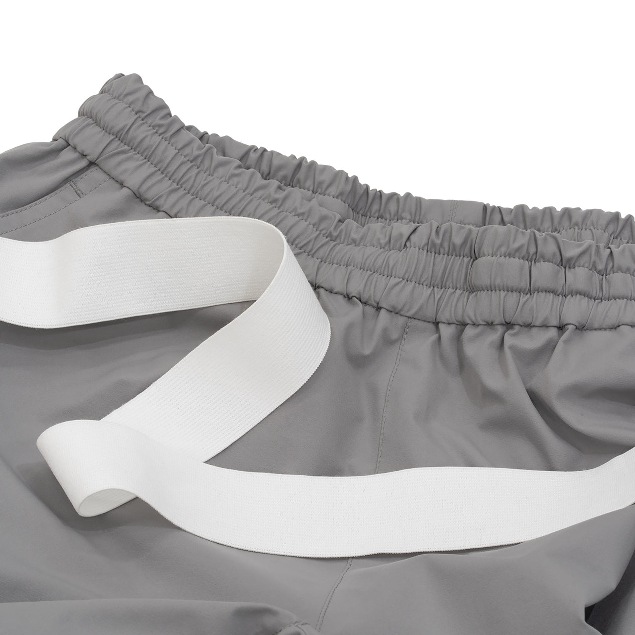 RIDGE MOUNTAIN GEAR Unwind Pants アンワインドパンツ ウエストに使用する白い平ゴムテープと、本体ウエストのギャザー部分を並べた仕様説明（公式画像） - 山道具とULギアのお店 Ascend Lite