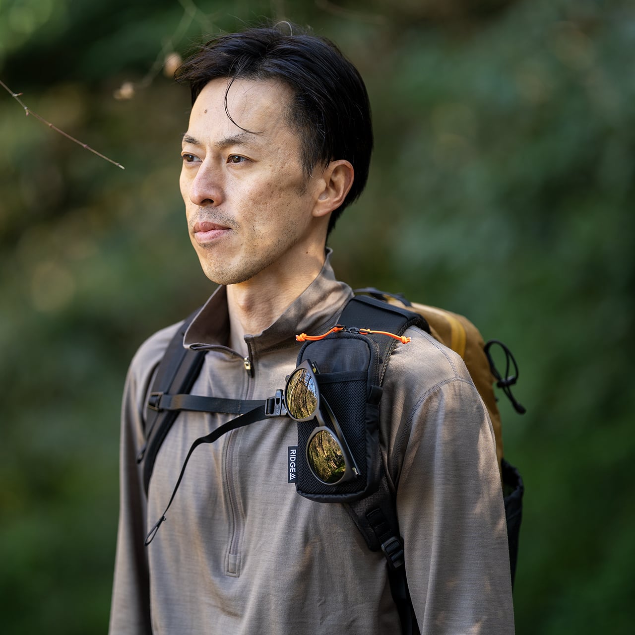 RIDGE MOUNTAIN GEAR Chest Increase チェストインクリース 胸元に装着した着用シーン（メッシュポケットにサングラスを収納）（公式画像） - 山道具とULギアのお店 Ascend Lite