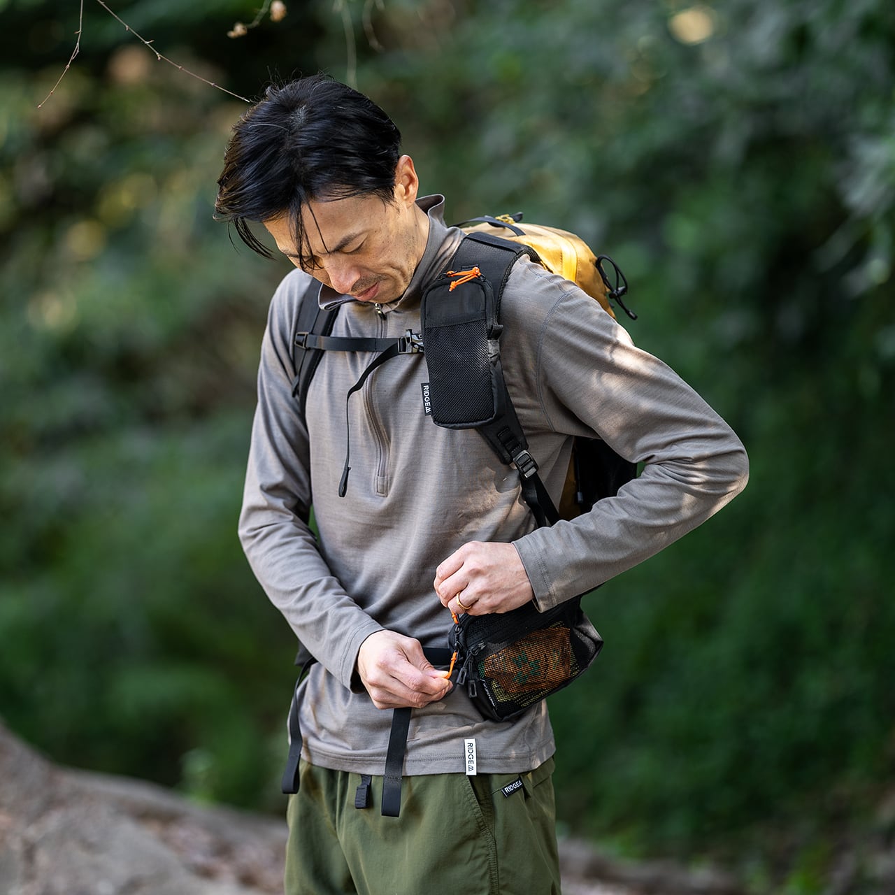 RIDGE MOUNTAIN GEAR Side Increase サイドインクリース 行動中にポケットから小物を取り出す様子（公式画像） - 山道具とULギアのお店 Ascend Lite