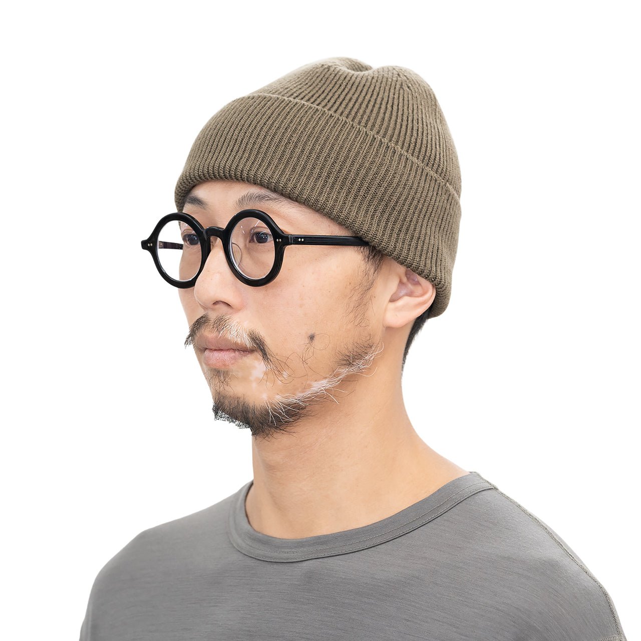RIDGE MOUNTAIN GEAR Merino PlaX Beanie メリノプラックスビーニー Olive Driftwood 男性モデルが裾を折り返してかぶった斜め横向きの着用イメージ（公式画像） - 山道具とULギアのお店 Ascend Lite