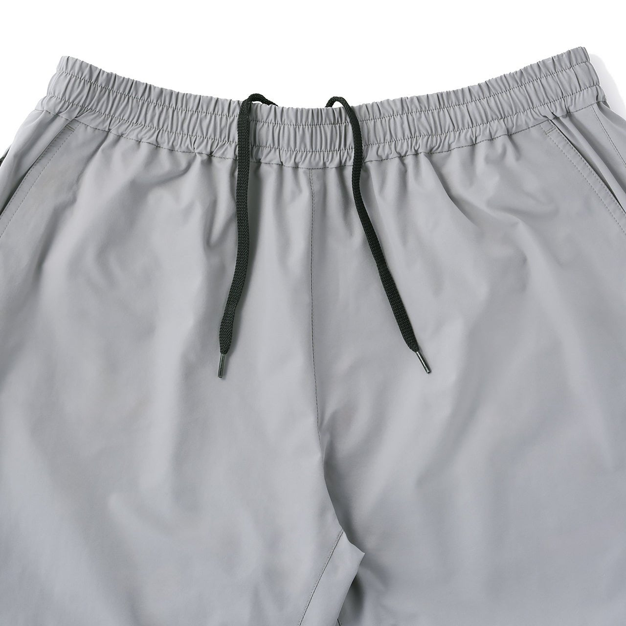 RIDGE MOUNTAIN GEAR Unwind Pants アンワインドパンツ ウエスト前面のギャザーと中央から引き出した黒い内蔵ドローコードの先端、両脇のポケット口のクローズアップ（公式画像） - 山道具とULギアのお店 Ascend Lite