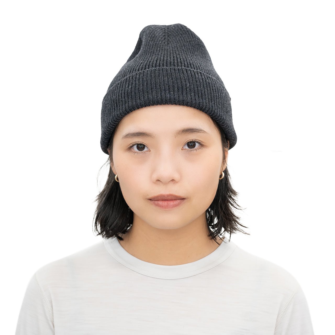 RIDGE MOUNTAIN GEAR Merino PlaX Beanie メリノプラックスビーニー Smoked Black 女性モデルが裾を折り返して浅くかぶった正面の着用イメージ（公式画像） - 山道具とULギアのお店 Ascend Lite