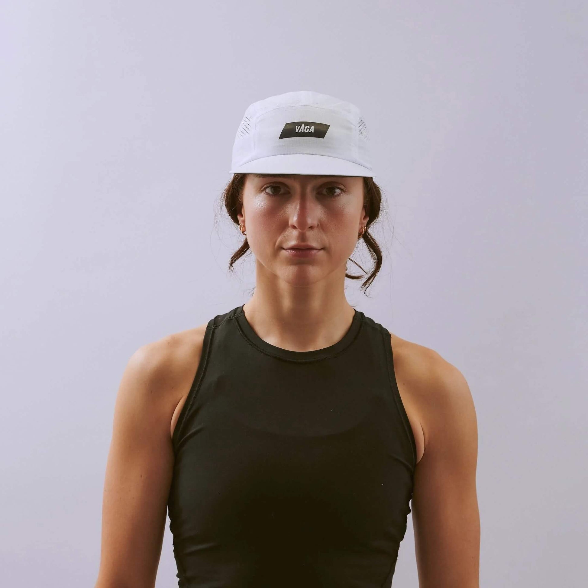 VAGA Feather Racing Cap フェザーレーシングキャップ ホワイト 着用イメージ 正面（公式画像） - タンクトップ姿の女性、眉の上で止まる浅い被り位置とフロント中央のVAGAラベル - 山道具とULギアのお店 Ascend Lite