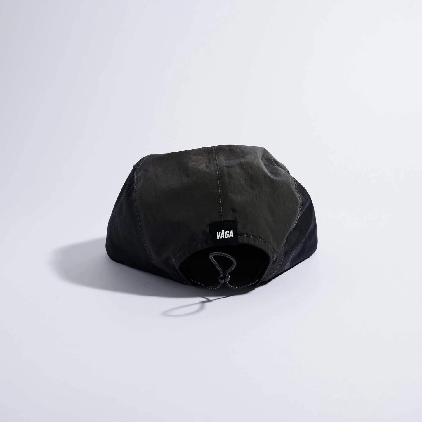 VAGA Pacer Cap ペーサーキャップ チャコール／ブラック／ブラウン 背面（公式画像） - 後頭部中央の黒いVAGAネームタグとエラスティックドローコード、垂れ下がるコードストッパー - 山道具とULギアのお店 Ascend Lite