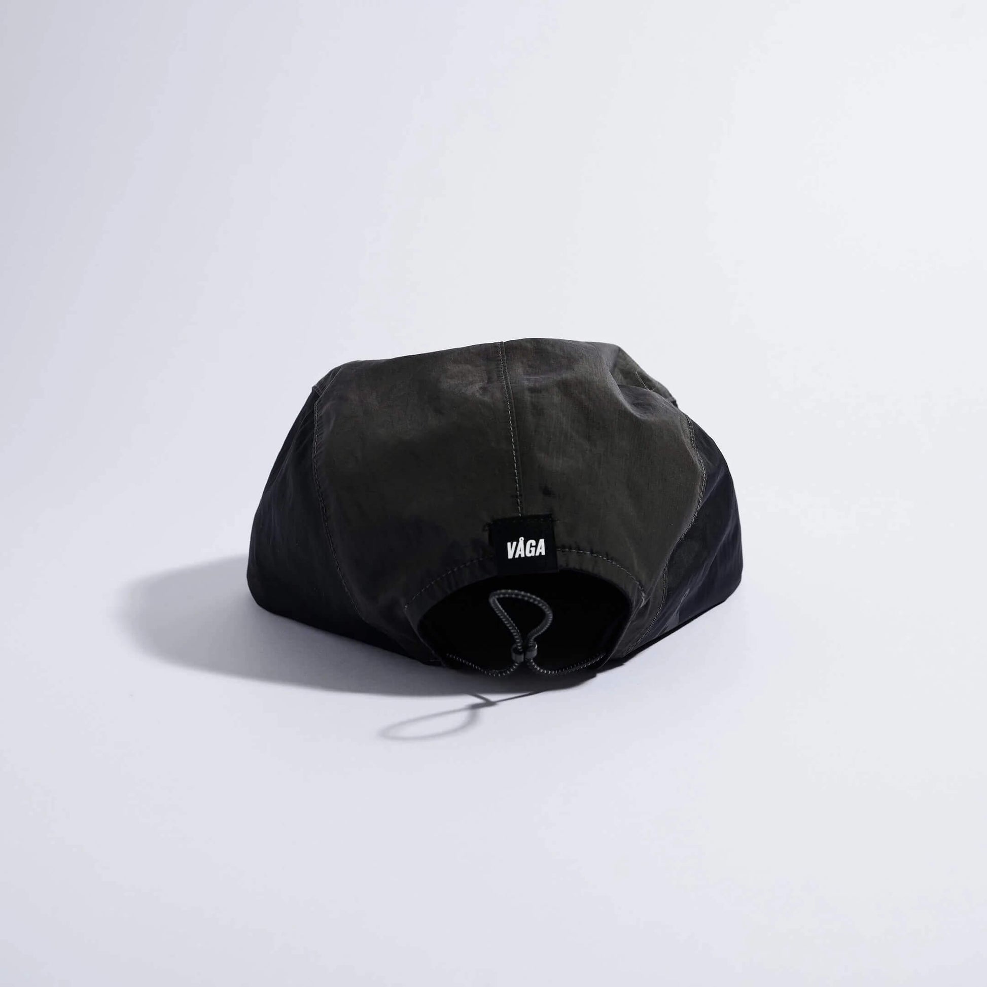 VAGA Pacer Cap ペーサーキャップ チャコール／ブラック／ブラウン 背面（公式画像） - 後頭部中央の黒いVAGAネームタグとエラスティックドローコード、垂れ下がるコードストッパー - 山道具とULギアのお店 Ascend Lite