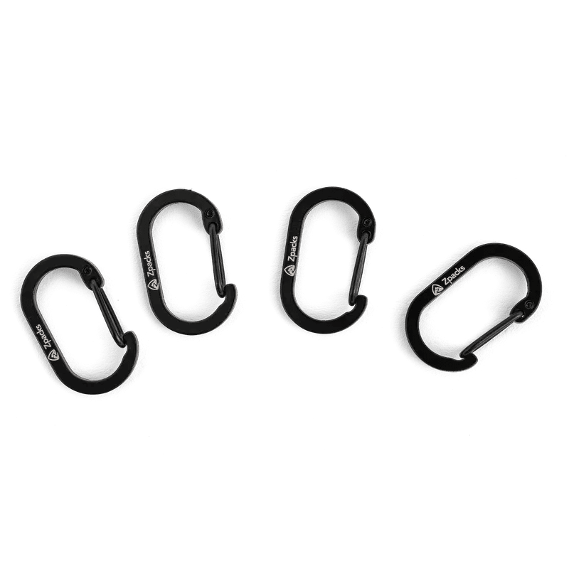 Zpacks Carabiner 4個セット カラビナ Tiny Oval ブラック 4個をグレー背景に扇状に並べた俯瞰 オーバル形状のボディとワイヤーゲート、Zpacksロゴが見える（公式画像） - 山道具とULギアのお店 Ascend Lite